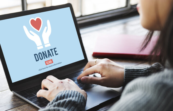 A woman working on a laptop with a Donate image on screen